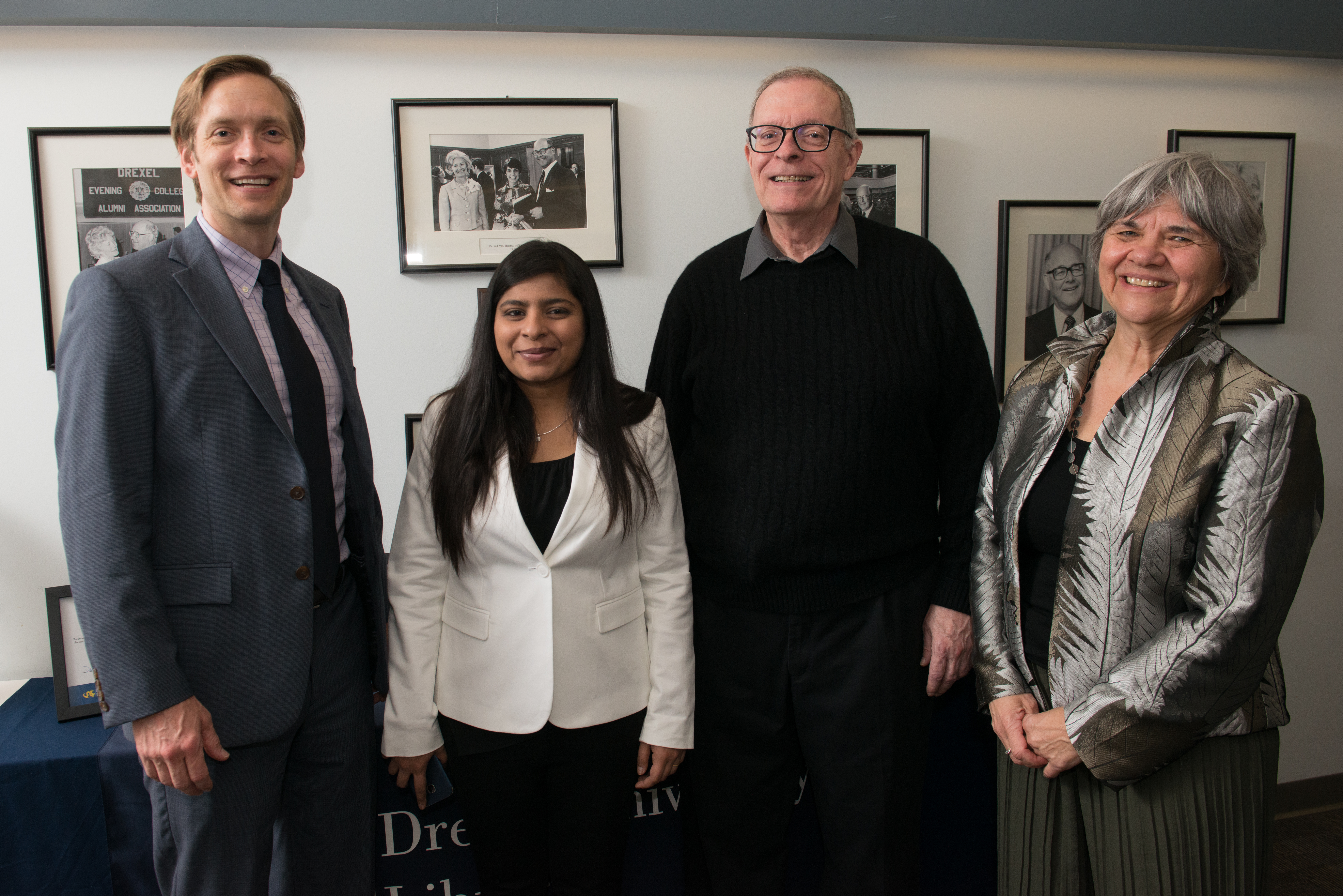 Two men and two women stand side-by-side and smile for the camera.